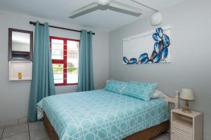 una camera con un letto blu e una finestra di Le Paradis 16 a Ballito