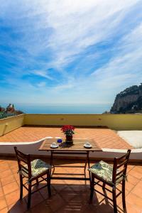 - une table et des chaises sur une terrasse avec vue sur l'océan dans l'établissement La Casa Dei Venti, à Amalfi