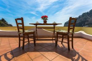 d'une table et de deux chaises avec une table et des fleurs sur le balcon. dans l'établissement La Casa Dei Venti, à Amalfi