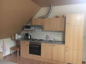 uma cozinha com armários de madeira e um forno com placa de fogão em Ferienwohnungen Eichenhof em Schneverdingen