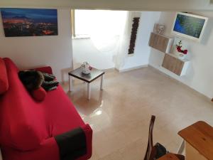 ein Wohnzimmer mit einem roten Sofa und einem Tisch in der Unterkunft La Maison di Tiziana in Neapel
