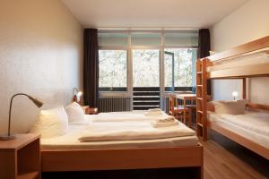 a bedroom with two beds and a large window at campushus in Sankt Peter-Ording