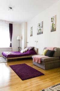 a bedroom with two beds and a couch in it at Andy's Home Central Apatment in Budapest