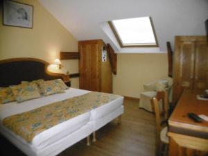 a bedroom with a bed and a desk and a window at Hôtel La Flore in Villefranche-sur-Mer
