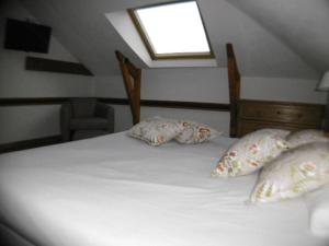a bedroom with a bed with pillows and a window at Hôtel La Flore in Villefranche-sur-Mer