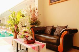 salon ze skórzaną kanapą i kwiatami w obiekcie Nok resort & hotel w mieście Ban Thung Khao Tok