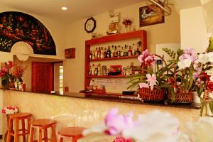 un restaurante con un bar con sillas y flores en Nok resort & hotel, en Ban Thung Khao Tok
