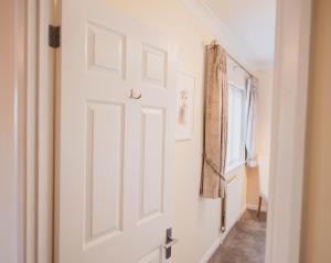 a white door in a hallway with a window at Riseden Bed and Breakfast in Maidstone