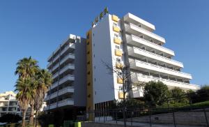 a tall white building with a sign on it at Hotel Luar in Portimão