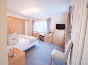 a bedroom with a bed and a desk and a television at Riseden Bed and Breakfast in Maidstone