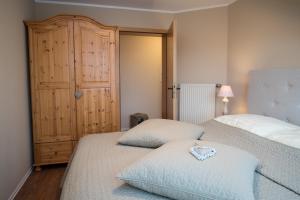 a bedroom with two beds and a closet at Landhotel Eifellust in Schalkenmehren