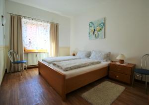 un dormitorio con una cama y una ventana en Gaestehaus Kön - Fewo Farfalle, en Zeltingen-Rachtig 17 fotos más