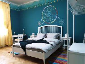 una camera da letto con pareti blu, un letto e un murale su ruote di Downtown Vibes Belle Vue Apartments a Timişoara