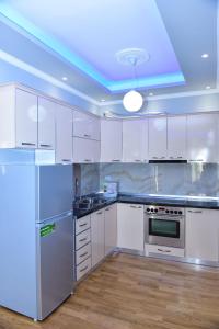 uma cozinha com armários brancos e um tecto azul em Durres Luxury Beach Apartment em Durrës