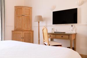 a hotel room with a bed and a television at Hôtel Les Mouettes - Les Collectionneurs in Ajaccio