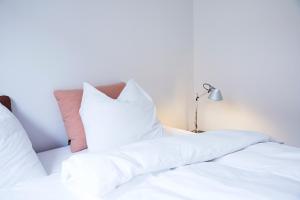 two white pillows on a bed with a lamp at Amaliegade 10 B in Aarhus