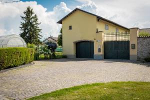 a house with a garage and a driveway at Cascina Tetto del Priore in Cuneo