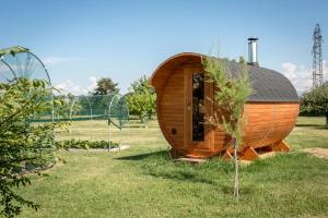 a wooden cabin in a field with a tree at Cascina Tetto del Priore in Cuneo