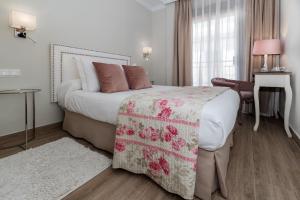 a bedroom with a bed and a desk and a window at Hostal Boutique Plaza Cantarero in Nerja