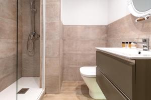 a bathroom with a shower and a toilet and a sink at Hostal Boutique Plaza Cantarero in Nerja