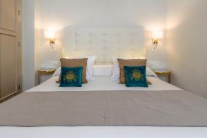 a bedroom with a bed with blue pillows at Hostal Boutique Plaza Cantarero in Nerja