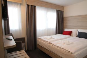 a bedroom with a large bed and a window at Wego Hotel in Bulle