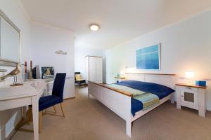 宾茨Residenz am Klünderberg by Rujana的一间卧室配有一张床、一张书桌和一张书桌