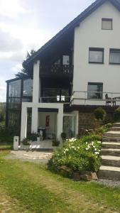Casa blanca grande con balcón y escaleras en Ferienwohnungen Thomsen Bergdorf Pobershau en Marienberg