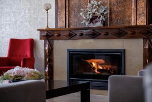 - un salon avec une cheminée et une table dans l'établissement Hotel Regina, à Fátima