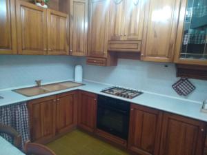 a kitchen with wooden cabinets and a sink and a stove at Casa Lory in Marone +25 photos