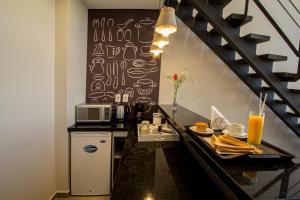 a kitchen with a counter with a microwave and a table at Hotel Le Pelican in Asunción