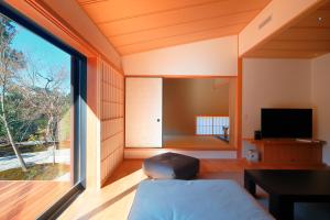 Zimmer mit einem Bett und einem großen Fenster in der Unterkunft Aoi Suites at Nanzenji Modern & Traditional Japanese Style in Kyoto