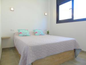 A bed or beds in a room at Appartement proche mer avec piscine Rosas