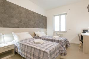 1 dormitorio con 2 camas, escritorio y lavamanos en B&B Open Doors Verona, en Verona 24 fotos más