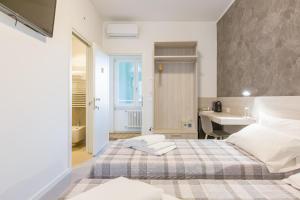 ein weißes Schlafzimmer mit einem Bett und einem Waschbecken in der Unterkunft B&B Open Doors Verona in Verona
