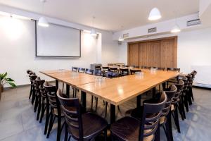 duża sala konferencyjna z dużym drewnianym stołem i krzesłami w obiekcie Hotel Jitřenka w mieście Konstantinovy Lázně