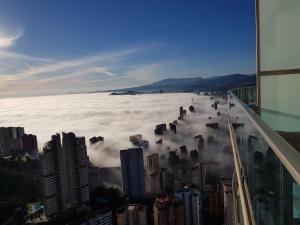 - une vue sur une ville dans les nuages depuis un bâtiment dans l'établissement 42nd floor - Penthouse VIP with private terrace and sea views, à Benidorm