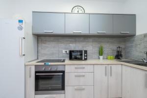 a kitchen with white cabinets and a microwave at Balen city central house for 8 in Novalja