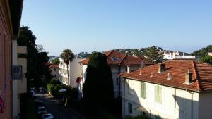 a city street with buildings and a large tree at Hotel Marcellin in Beaulieu-sur-Mer