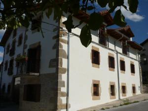 een groot wit gebouw met ramen en balkons bij Casa Rural Erburu in Urdiáin