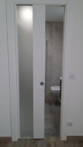 a bathroom with a toilet and a white door at Hotel Marcellin in Beaulieu-sur-Mer