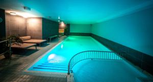 a large swimming pool with a blue light in a building at Hotel Saint Sauveur by WP Hotels in Blankenberge