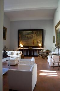 a living room with white furniture and a large painting on the wall at Casa Schlatter in Florence