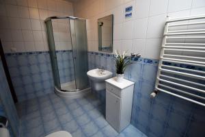 a blue tiled bathroom with a toilet and a sink at Willa Akord in Władysławowo