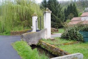 a stone bridge with a gate in a yard at moulin de rouchillou in Saint-Martial-de-Valette