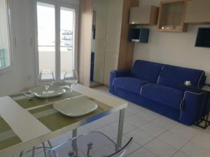 a living room with a blue couch and two wine glasses at Alery apartment with terrace AC wifi 7th floor a few meters from the sea by Affitto-Nizza in Nice