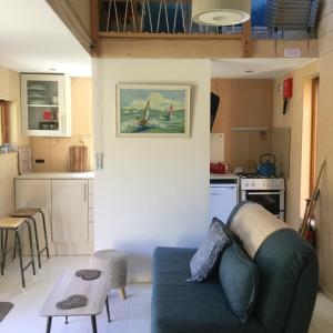Una sala de estar con un sofá y una cocina. en Tiny Home cabin Eilidh, en Cowes