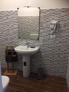 uma casa de banho com um lavatório, um espelho e um WC. em Katane Apartment em Catânia