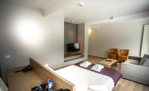 une chambre d'hôtel avec un lit et un canapé dans l'établissement Hotel Saint Sauveur by WP Hotels, à Blankenberge