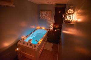 巴利里芬的住宿－拜洛里芬Spa旅館，浴室配有带灯的浴缸。